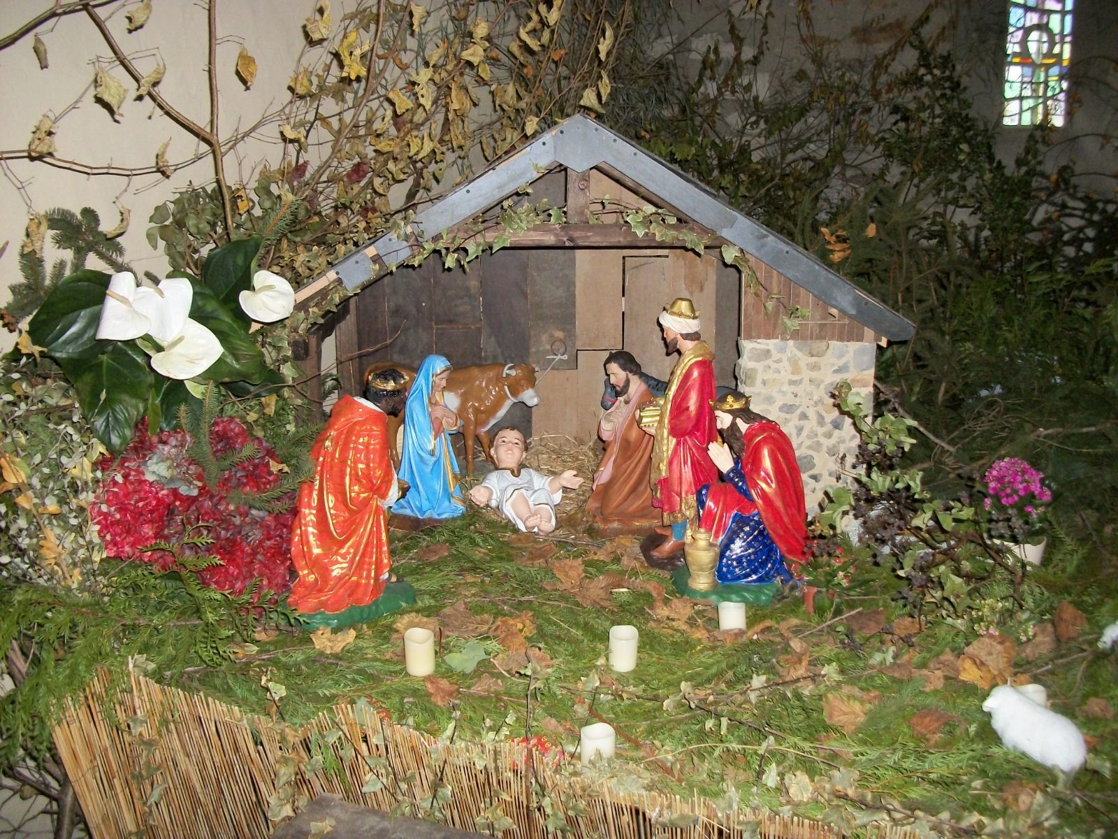 Un pesebre sencillo y luminoso: un establo de madera, la Sagrada Familia y algunas figuras